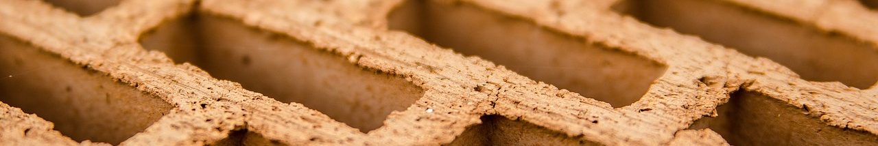 Strukturierte Wellenform aus braunem Material mit rechteckigen Ausschnitten.